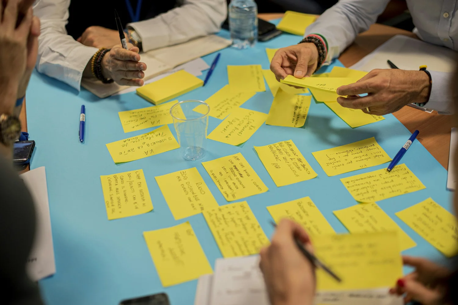 Team brainstorming with yellow sticky notes on a blue table